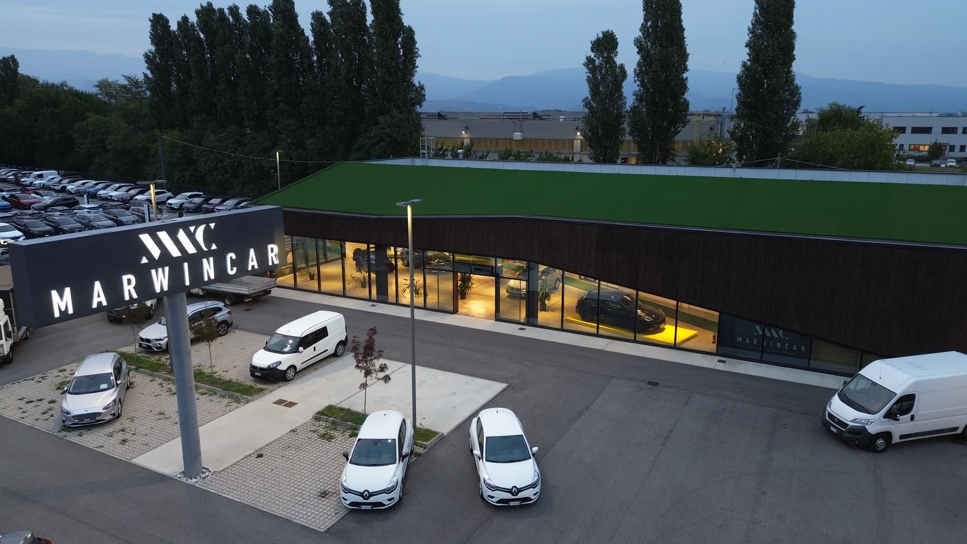 Veduta aerea della sede Marwincar al tramonto, con l’insegna luminosa e lo showroom